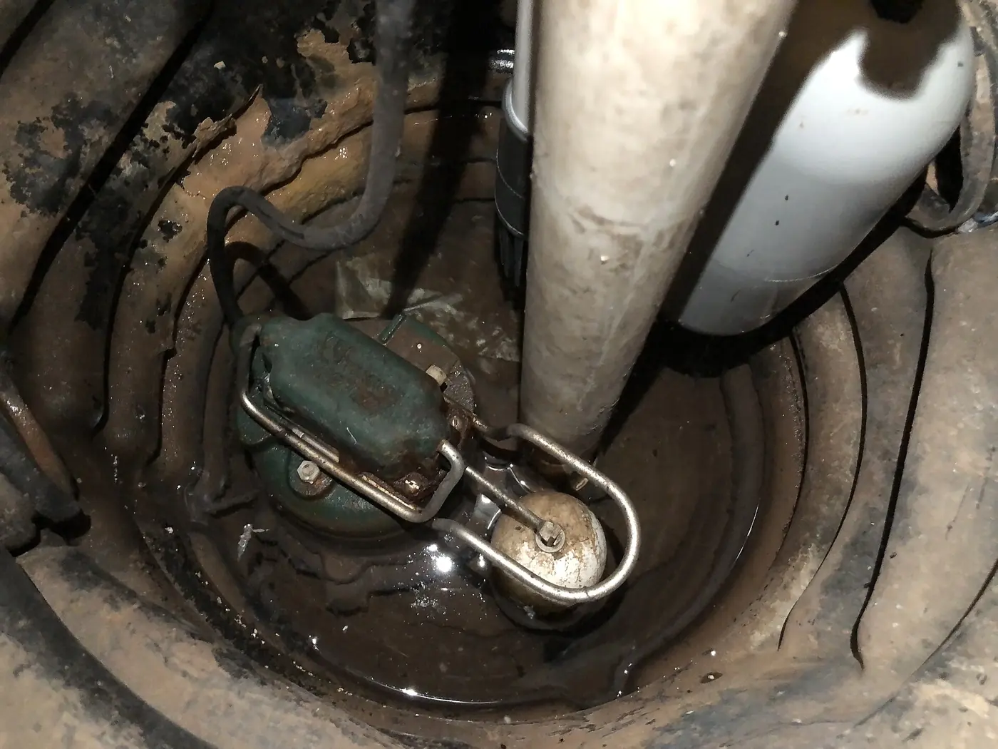Sump pump with a float switch sitting in a basement sump pit.